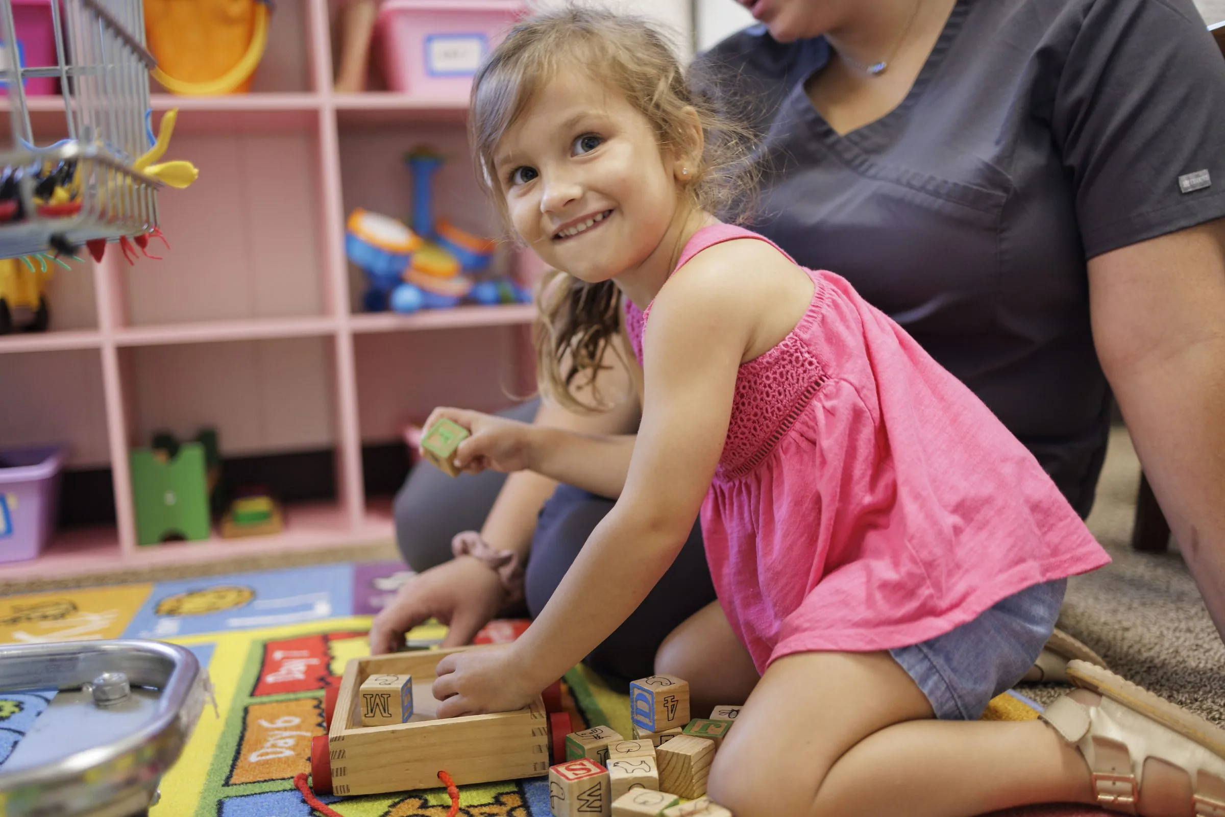 A young girl playing with blocks at Parents Day Out