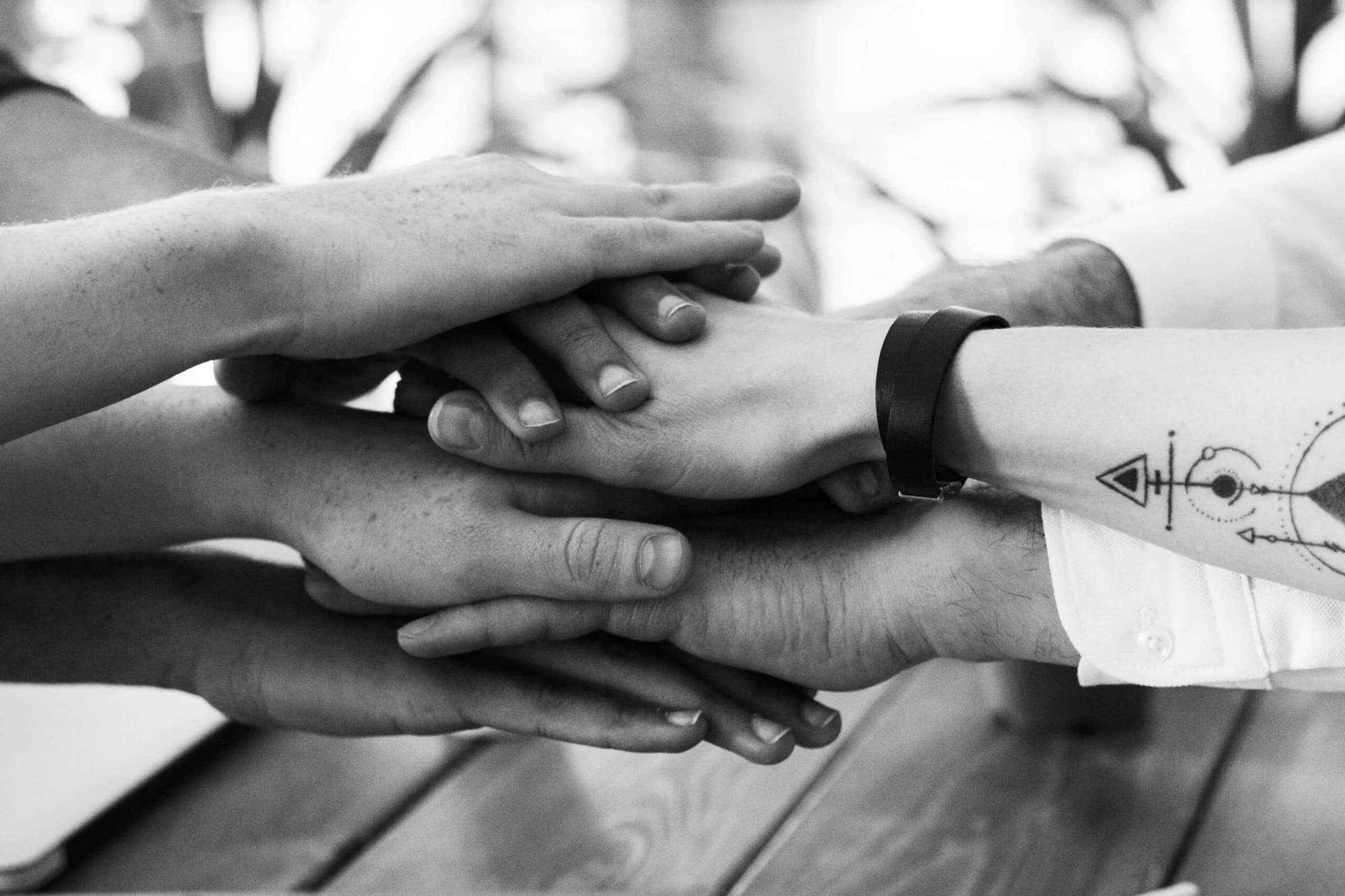 Hands joined together in the middle of a group